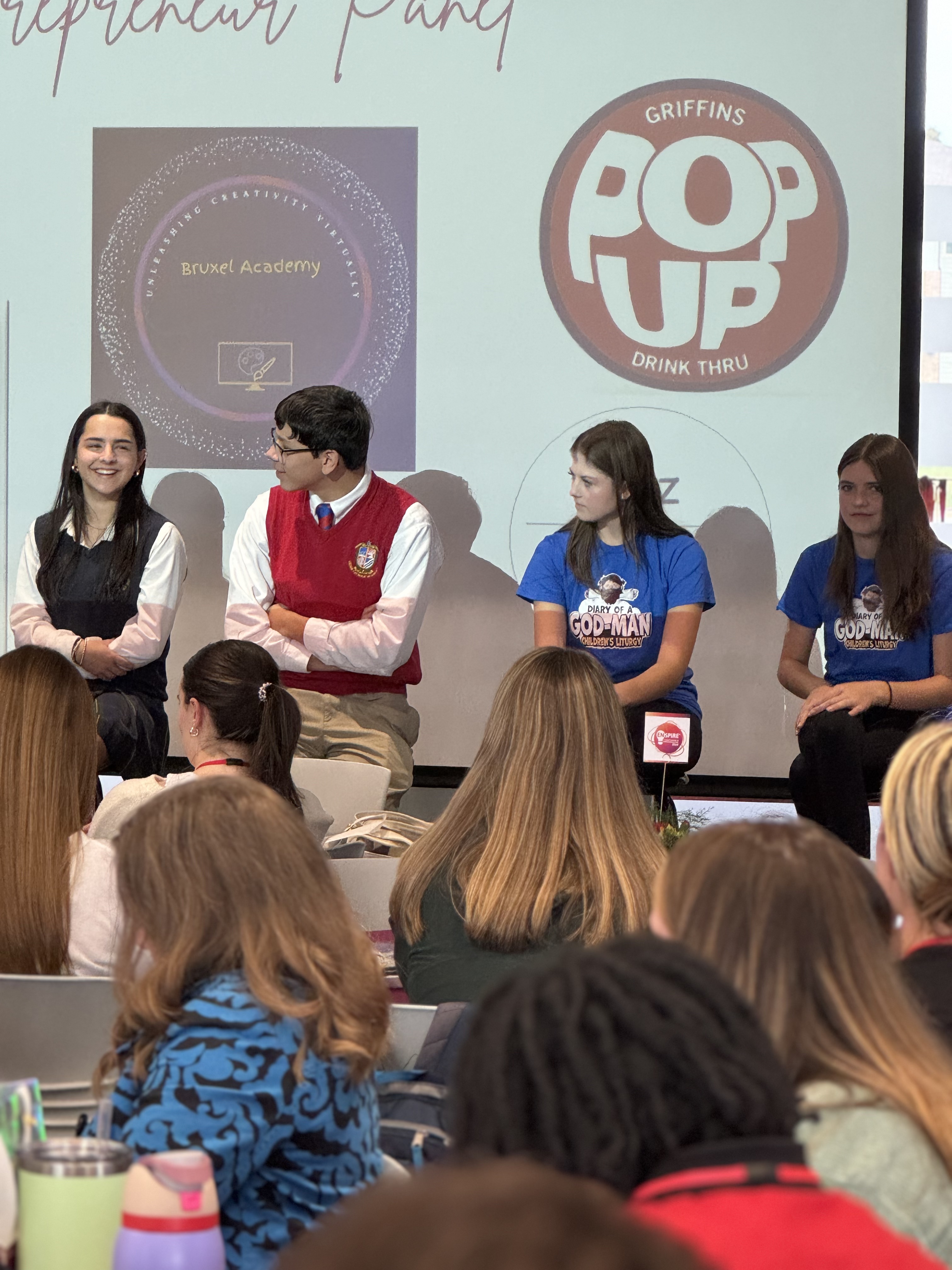 Students presenting their PopUp business experience to an audience, sharing their entrepreneurial journey
