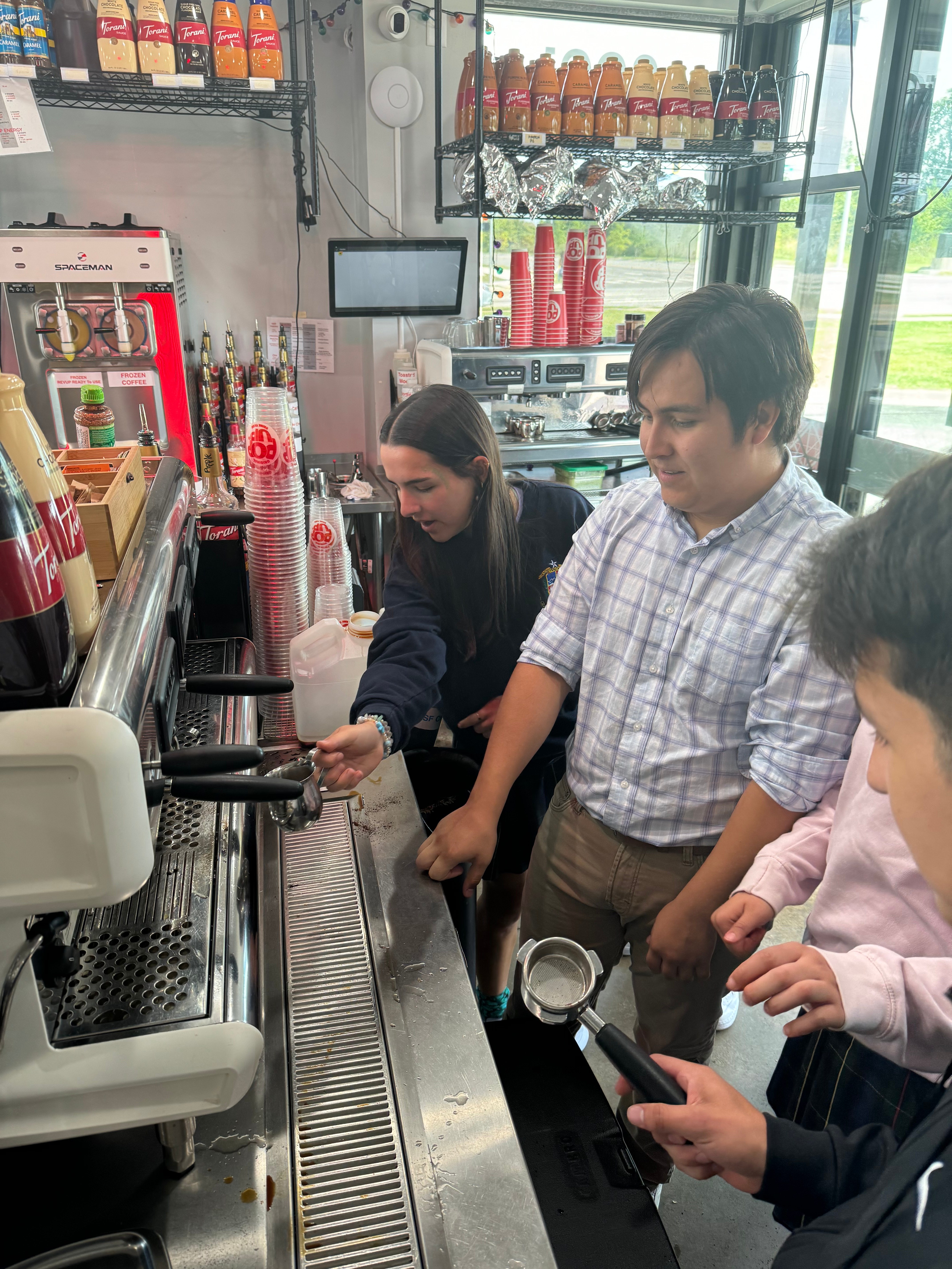 Students learning hands-on beverage preparation with professional equipment and instructor guidance